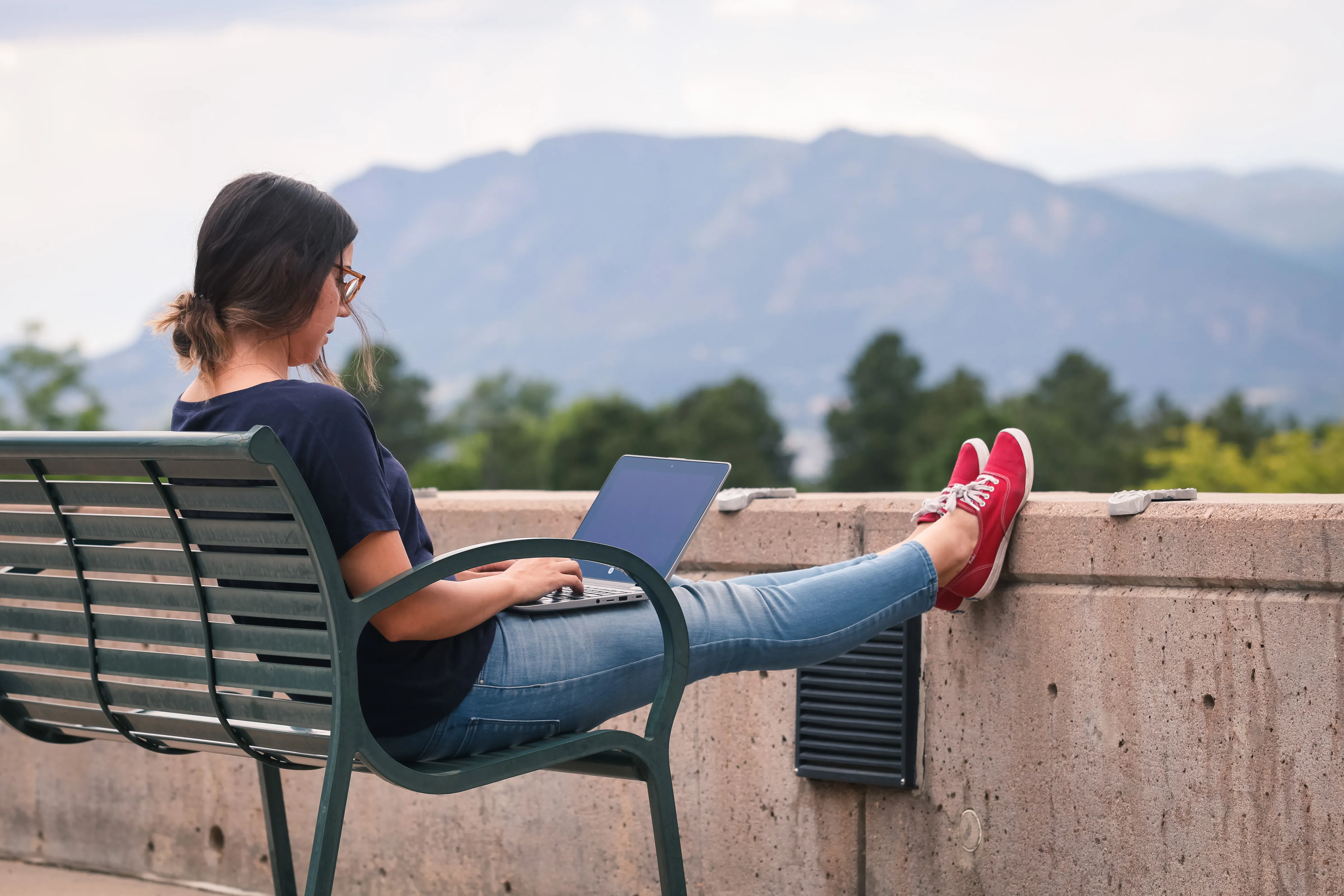 student working on their computer in front of mountain backdrop