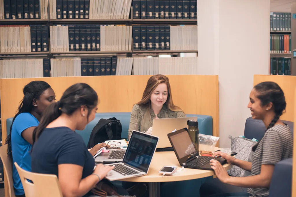 students working together on their computers in the library